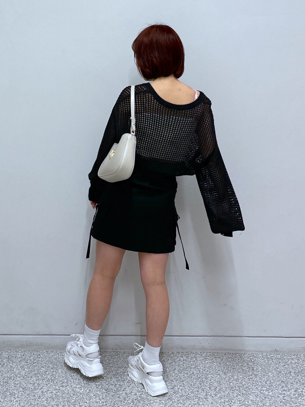 ホワイト系のサンダル、ブラック系のカーディガン/ボレロ、ブラック系のスカートを着用したレディースの春コーディネートの5枚目の写真