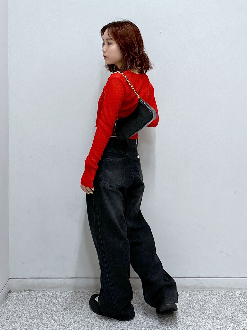 レッド系のカーディガン/ボレロ、ブラック系のトートバッグ、ブラック系のキャミソールを着用したレディースの秋コーディネートの4枚目の写真