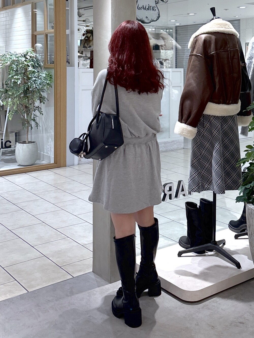 グレー系のワンピース、ブラック系のトートバッグ、ブラック系のブーツを着用したレディースの秋コーディネートの7枚目の写真