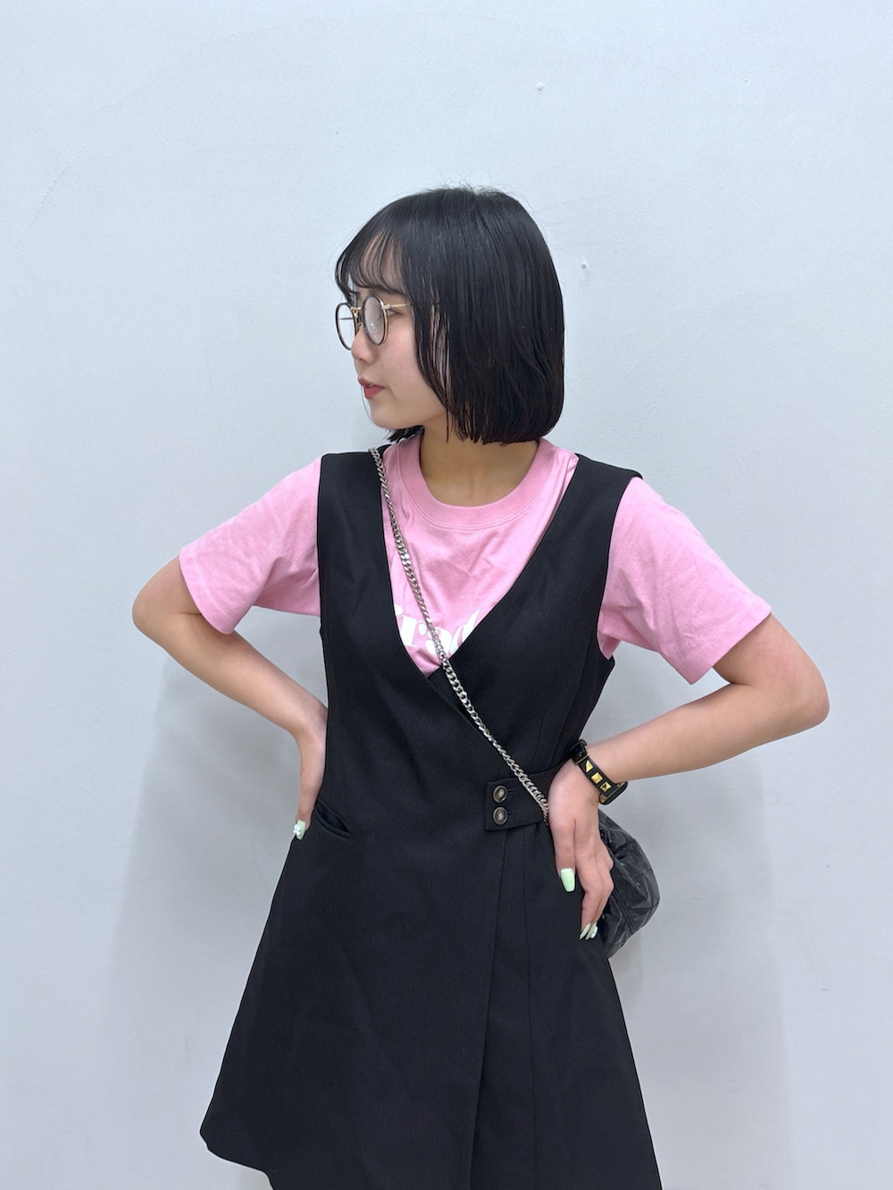 ブラック系のジャンパースカート、ブラック系のサンダル、ピンク系のTシャツ/カットソーを着用したレディースの春コーディネートの5枚目の写真