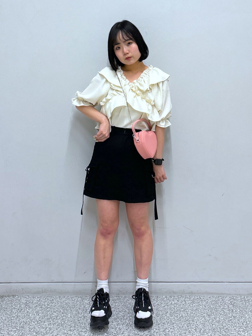 ブラック系のサンダル、ブラック系のスカート、ホワイト系のシャツ/ブラウスを着用したレディースの春コーディネートの2枚目の写真