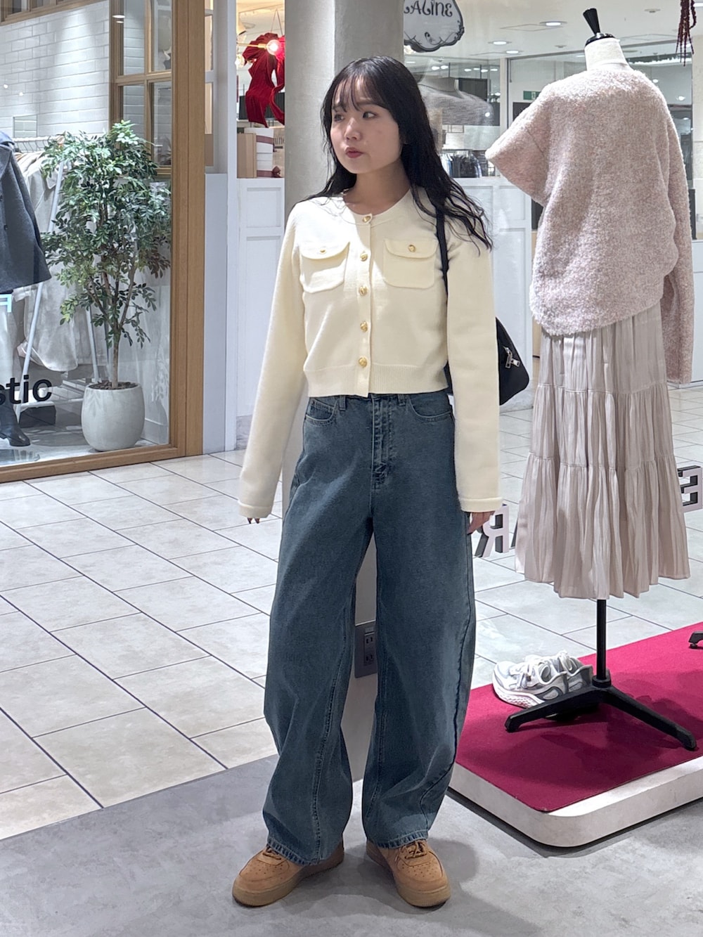 ホワイト系のニット/セーター、ベージュ系のスニーカー、ブラック系のハンドバッグを着用したレディースの冬コーディネートの3枚目の写真