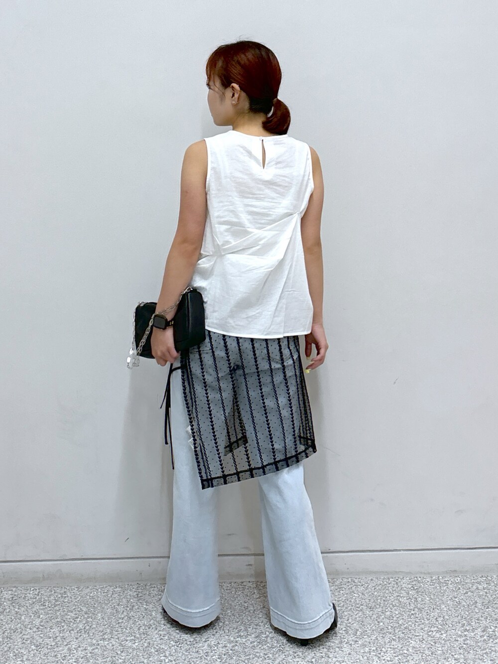 ホワイト系のシャツ/ブラウス、ブラック系のスカート、ブルー系のデニムパンツを着用したレディースの夏コーディネートの4枚目の写真