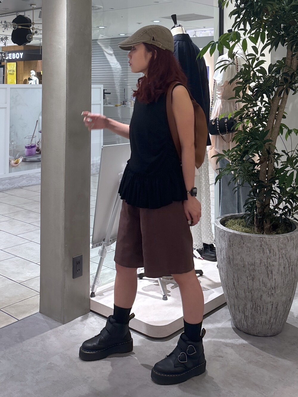 ブラウン系のデニムパンツ、ブラック系のブーツ、ブラック系のTシャツ/カットソーを着用したレディースの夏コーディネートの4枚目の写真