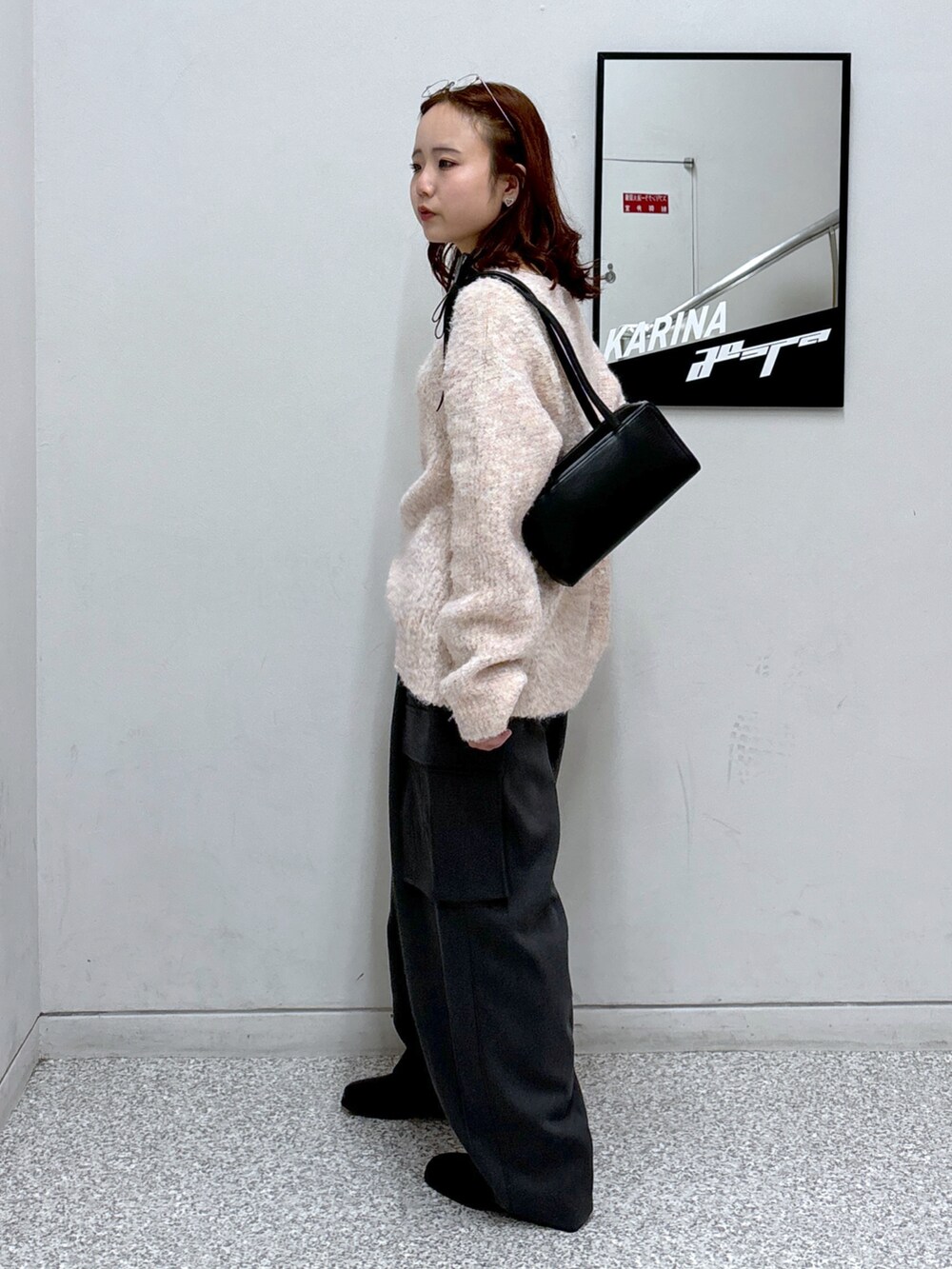 ピンク系のニット/セーター、グレー系のカーゴパンツ、ブラック系のブーツを着用したレディースの冬コーディネートの4枚目の写真