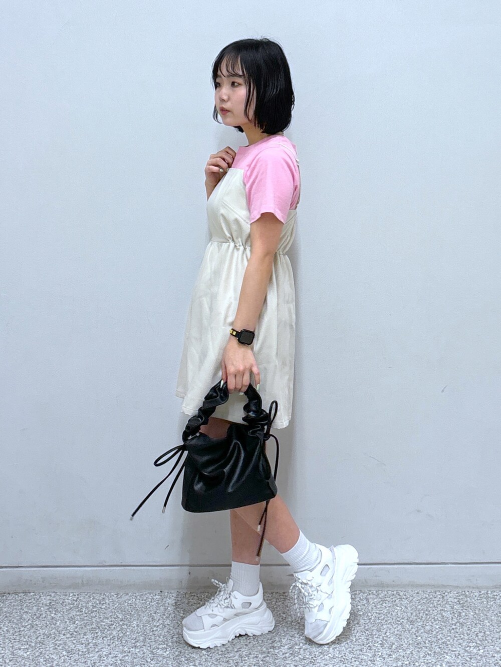 ホワイト系のサンダル、ホワイト系のワンピース、ピンク系のTシャツ/カットソーを着用したレディースの春コーディネートの2枚目の写真