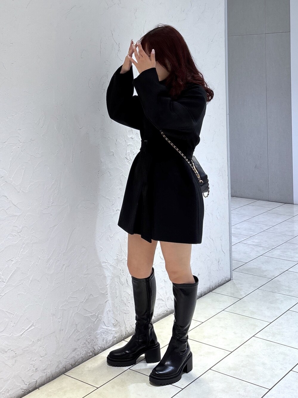 ブラック系のステンカラーコート、ブラック系のその他パンツ、ブラック系のショルダーバッグを着用したレディースの秋コーディネートの4枚目の写真