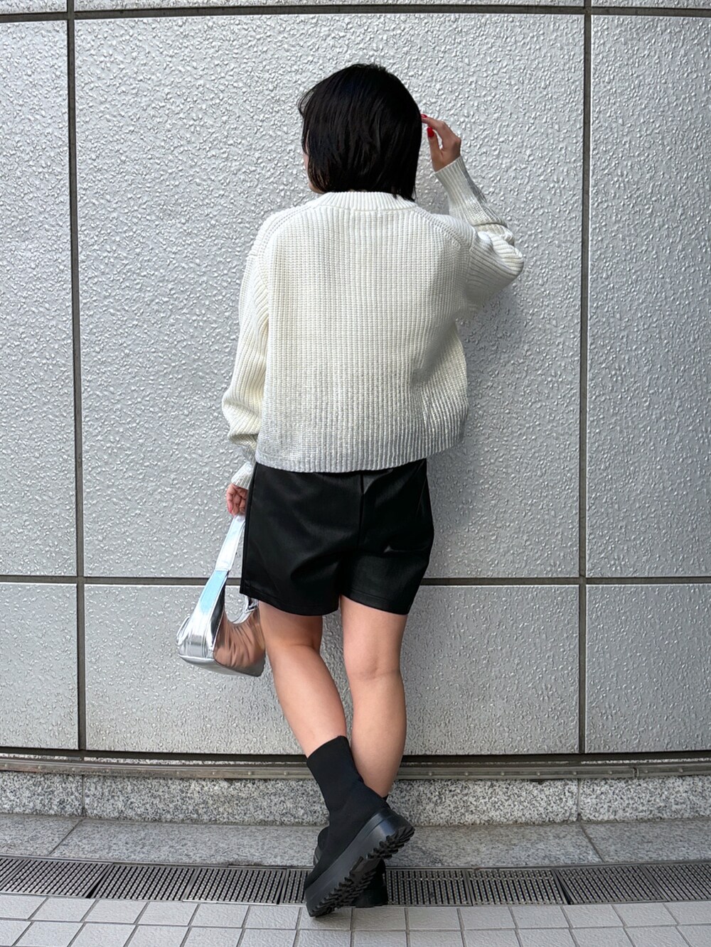 シルバー系のショルダーバッグ、ホワイト系のニット/セーター、ブラック系のその他パンツを着用したレディースの冬コーディネートの3枚目の写真