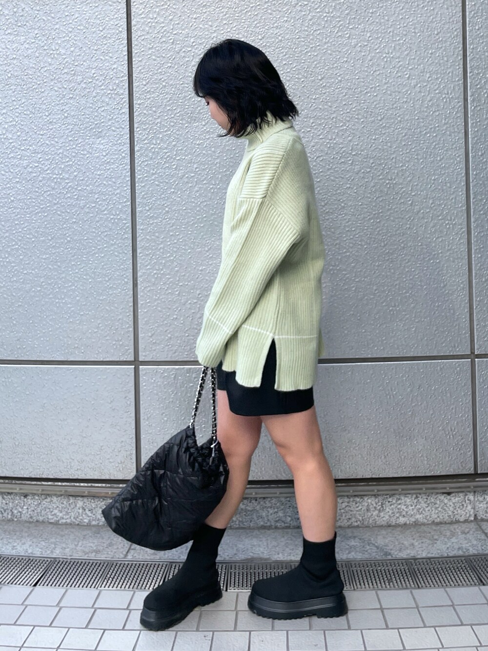 ブラック系のトートバッグ、ブラック系のその他パンツ、グリーン系のニット/セーターを着用したレディースの冬コーディネートの2枚目の写真