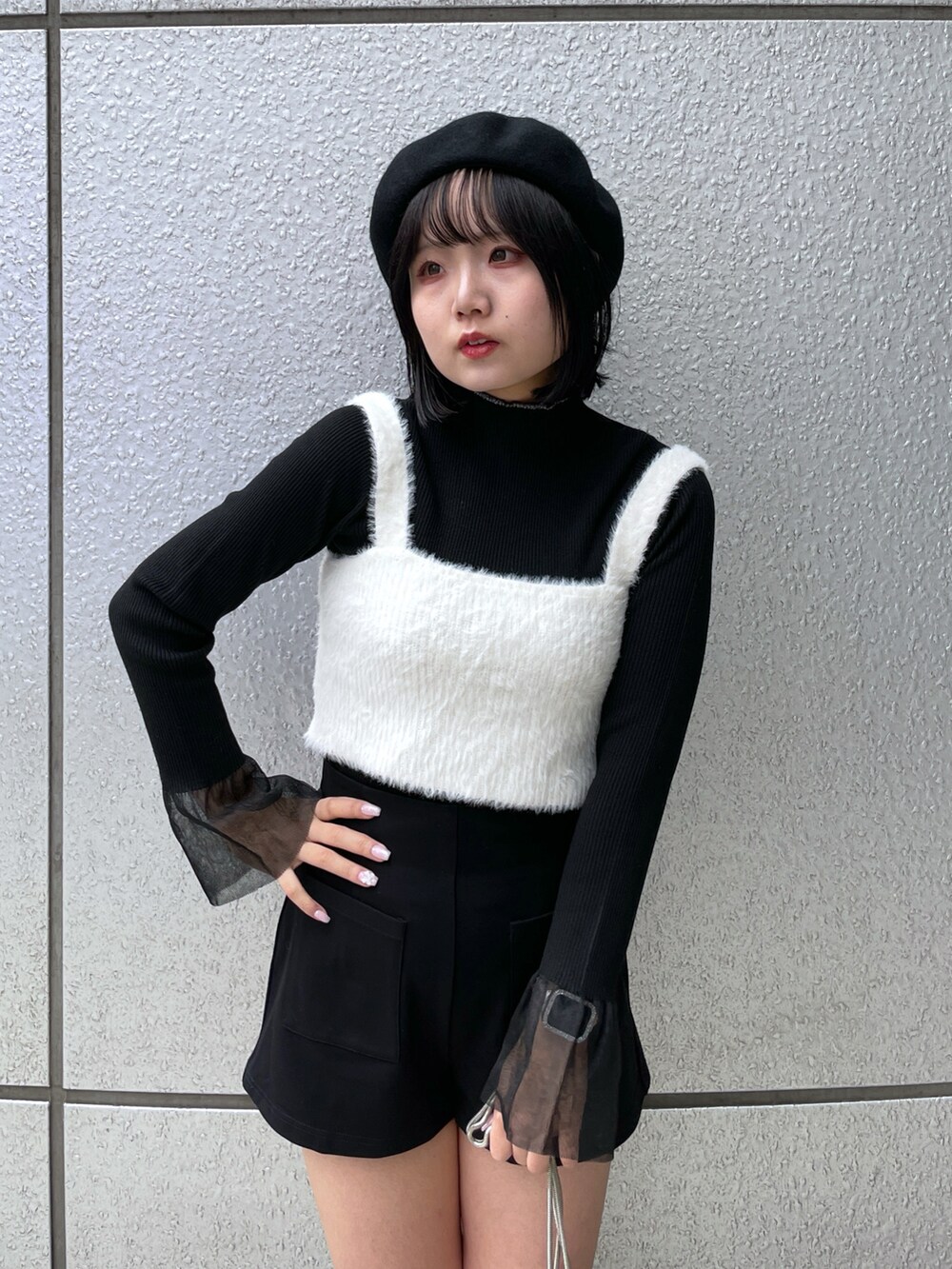 ホワイト系のベスト、ブラック系のその他パンツ、ブラック系のニット/セーターを着用したレディースの秋コーディネートの3枚目の写真