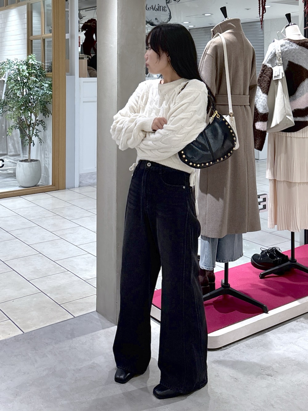 ホワイト系のニット/セーター、ブラック系のデニムパンツ、ブラック系のブーツを着用したレディースの冬コーディネートの4枚目の写真