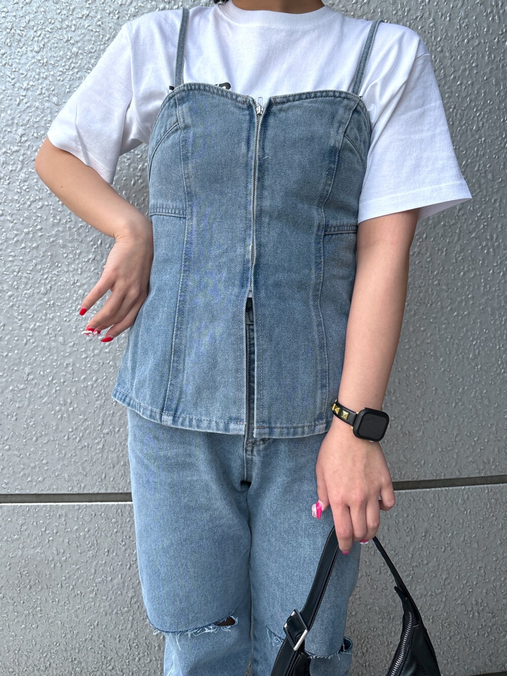 ブルー系のデニムパンツ、ブルー系のベスト、ホワイト系のTシャツ/カットソーを着用したレディースの春コーディネートの4枚目の写真