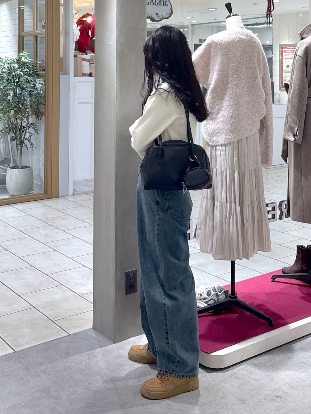 ホワイト系のニット/セーター、ベージュ系のスニーカー、ブラック系のハンドバッグを着用したレディースの冬コーディネートの6枚目の写真