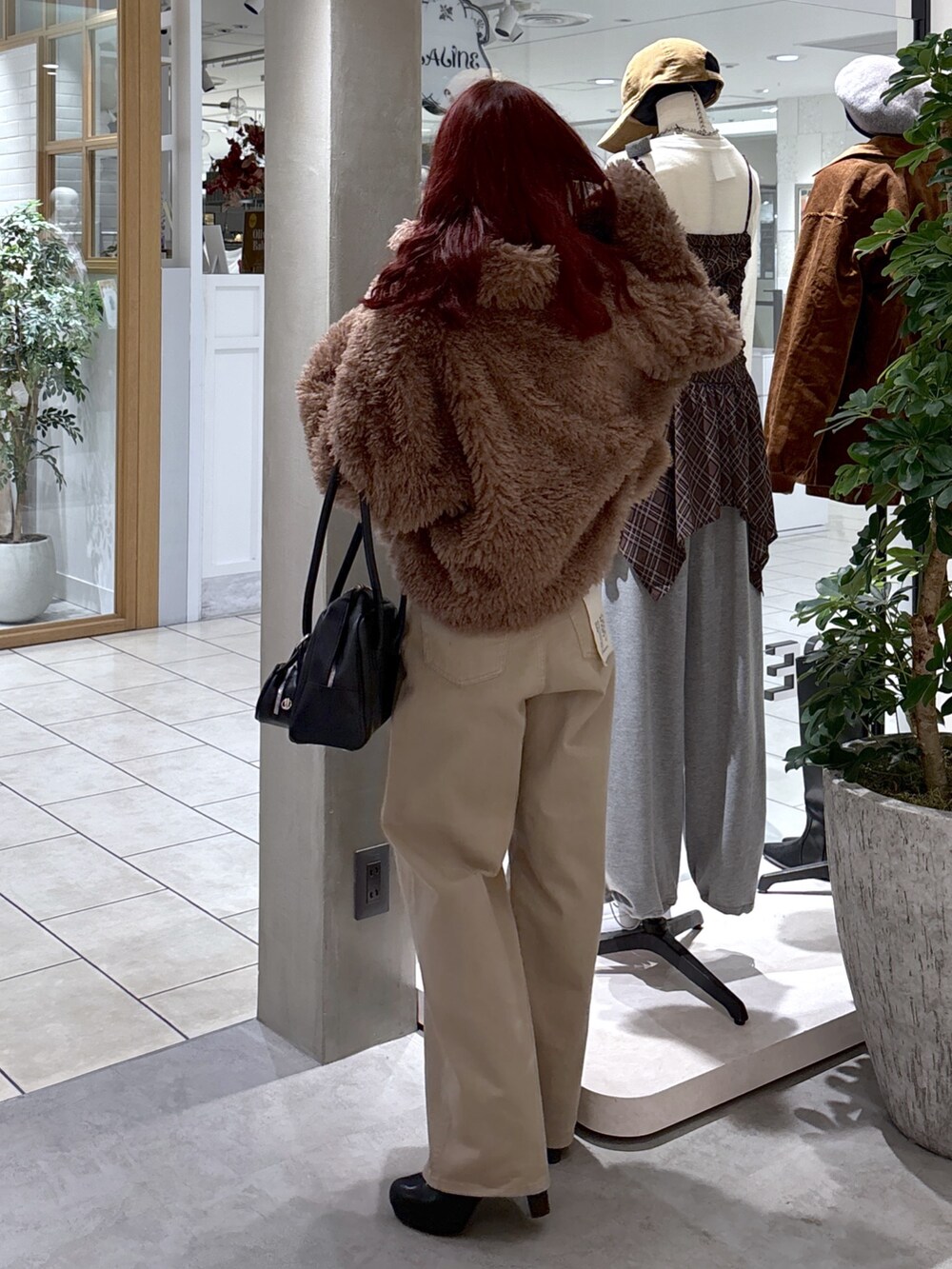 ブラウン系のブルゾン、ベージュ系のデニムパンツ、ブラック系のトートバッグを着用したレディースの秋コーディネートの8枚目の写真