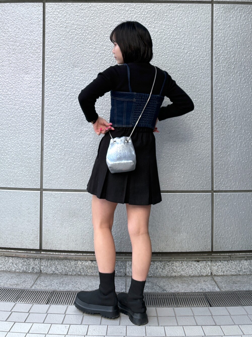 ブルー系のベスト、ブラック系のスカート、ブラック系のニット/セーターを着用したレディースの冬コーディネートの3枚目の写真