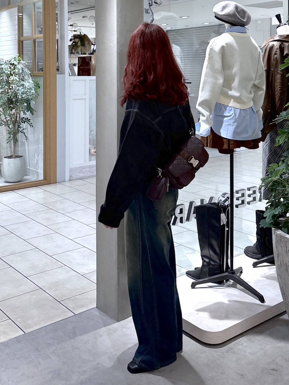 ブラック系のブルゾン、ブルー系のデニムパンツ、ブラウン系のショルダーバッグを着用したレディースの秋コーディネートの4枚目の写真