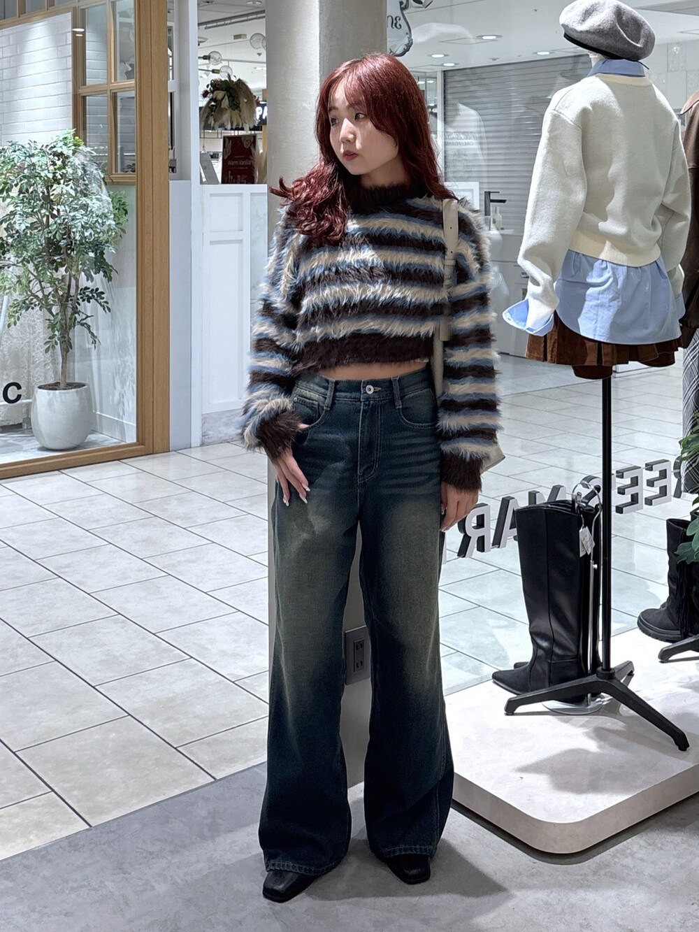 ブラウン系のニット/セーター、ブルー系のデニムパンツ、グレー系のショルダーバッグを着用したレディースの秋コーディネートの4枚目の写真