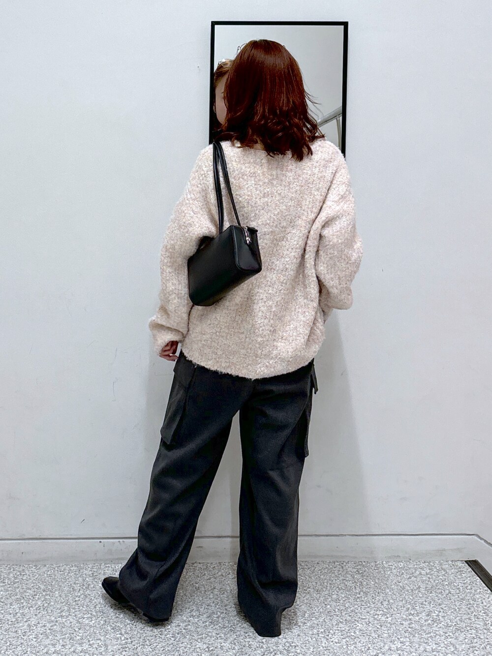 ピンク系のニット/セーター、グレー系のカーゴパンツ、ブラック系のブーツを着用したレディースの冬コーディネートの5枚目の写真