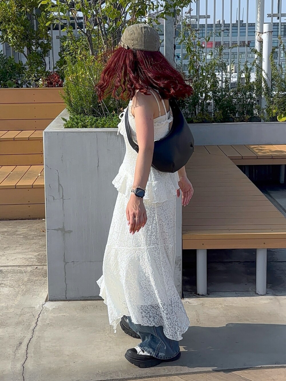 ホワイト系のワンピース、ブルー系のデニムパンツ、ホワイト系のスニーカーを着用したレディースの夏コーディネートの5枚目の写真