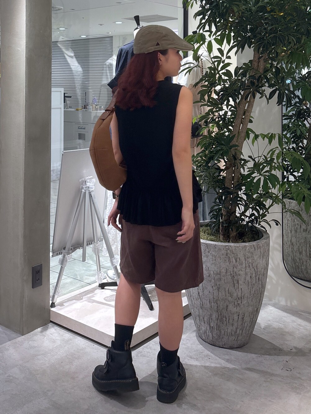 ブラウン系のデニムパンツ、ブラック系のブーツ、ブラック系のTシャツ/カットソーを着用したレディースの夏コーディネートの7枚目の写真