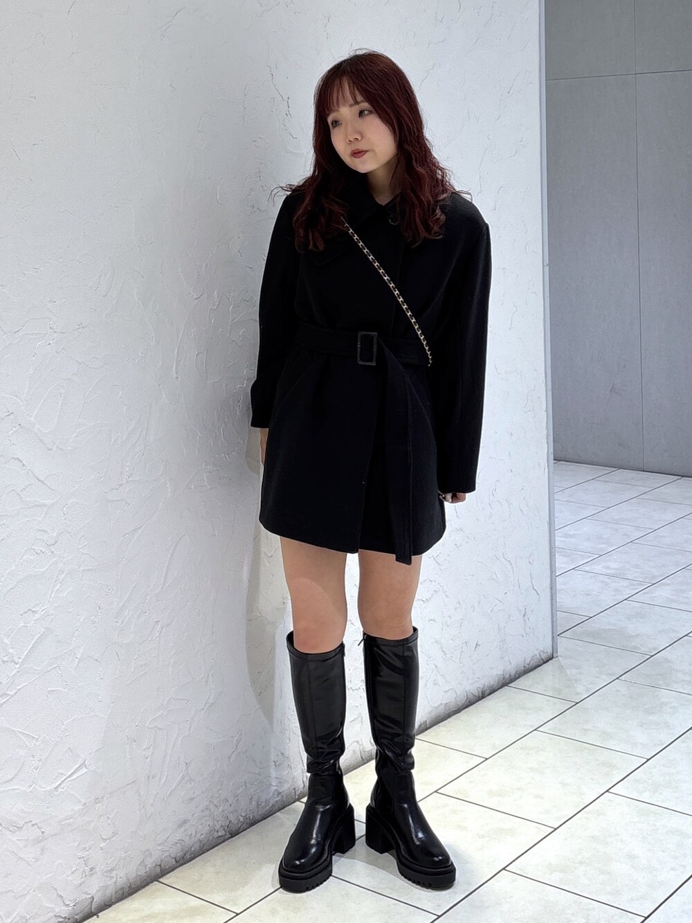 ブラック系のステンカラーコート、ブラック系のその他パンツ、ブラック系のショルダーバッグを着用したレディースの秋コーディネートの2枚目の写真