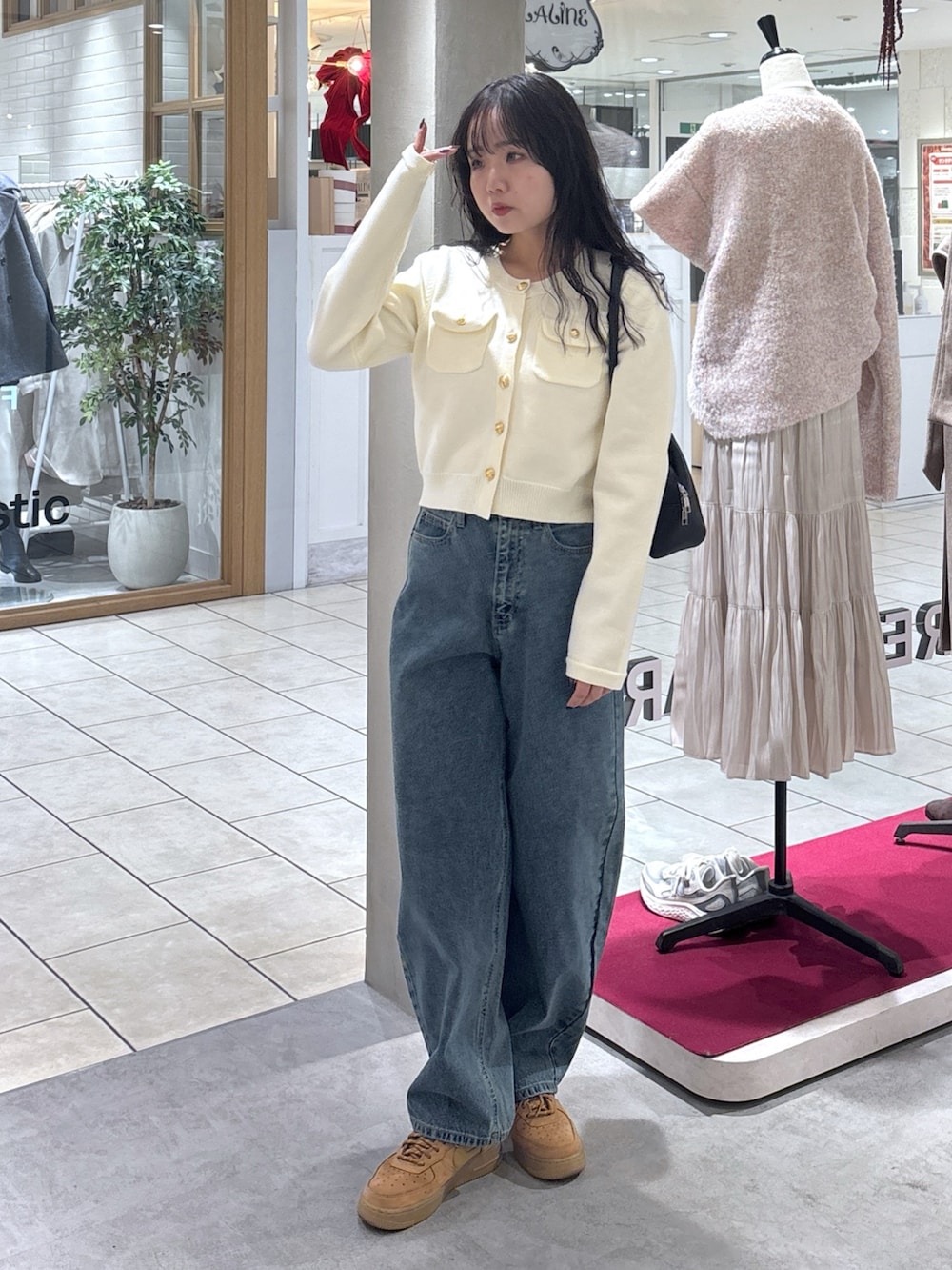 ホワイト系のニット/セーター、ベージュ系のスニーカー、ブラック系のハンドバッグを着用したレディースの冬コーディネートの2枚目の写真