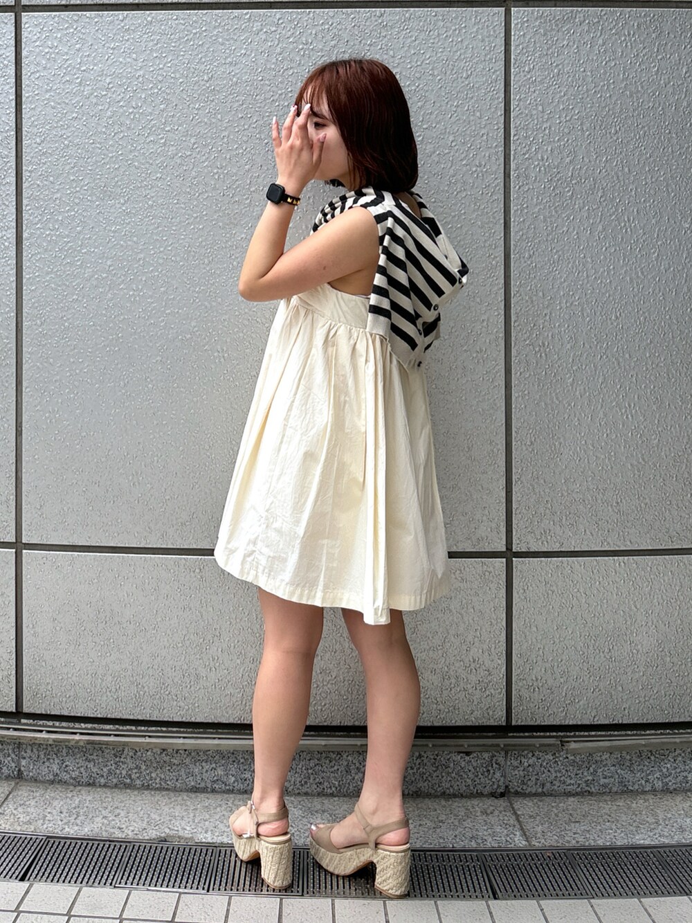 ホワイト系のワンピース、グレー系のカーディガン/ボレロ、グレー系のサンダルを着用したレディースの春コーディネートの3枚目の写真