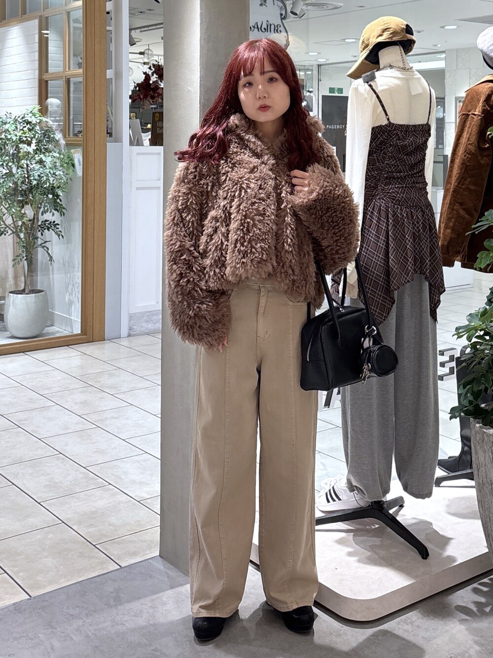 ブラウン系のブルゾン、ベージュ系のデニムパンツ、ブラック系のトートバッグを着用したレディースの秋コーディネートの2枚目の写真