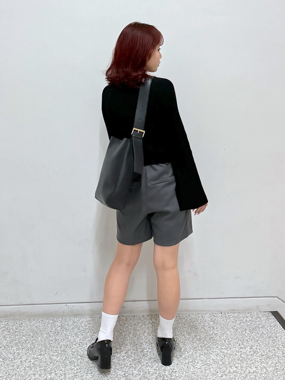 ブラック系のニット/セーター、グレー系のその他パンツ、ブラック系のローファーを着用したレディースの秋コーディネートの5枚目の写真