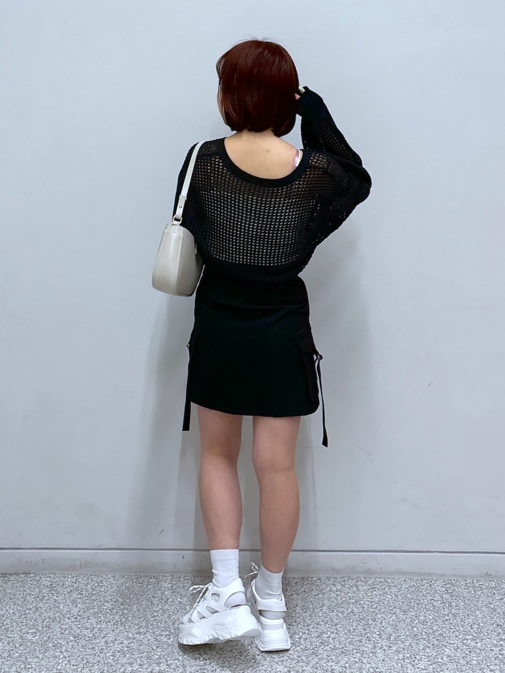 ホワイト系のサンダル、ブラック系のカーディガン/ボレロ、ブラック系のスカートを着用したレディースの春コーディネートの4枚目の写真