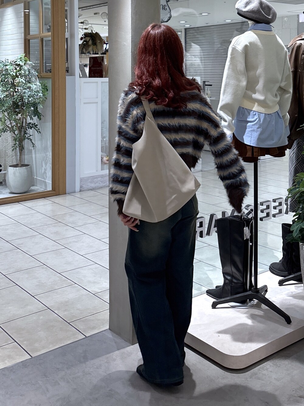 ブラウン系のニット/セーター、ブルー系のデニムパンツ、グレー系のショルダーバッグを着用したレディースの秋コーディネートの8枚目の写真