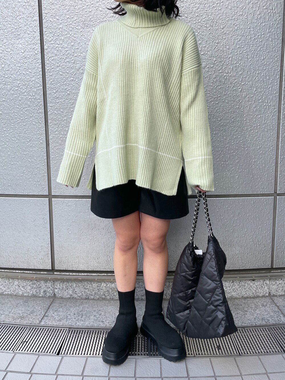 ブラック系のトートバッグ、ブラック系のその他パンツ、グリーン系のニット/セーターを着用したレディースの冬コーディネートの5枚目の写真