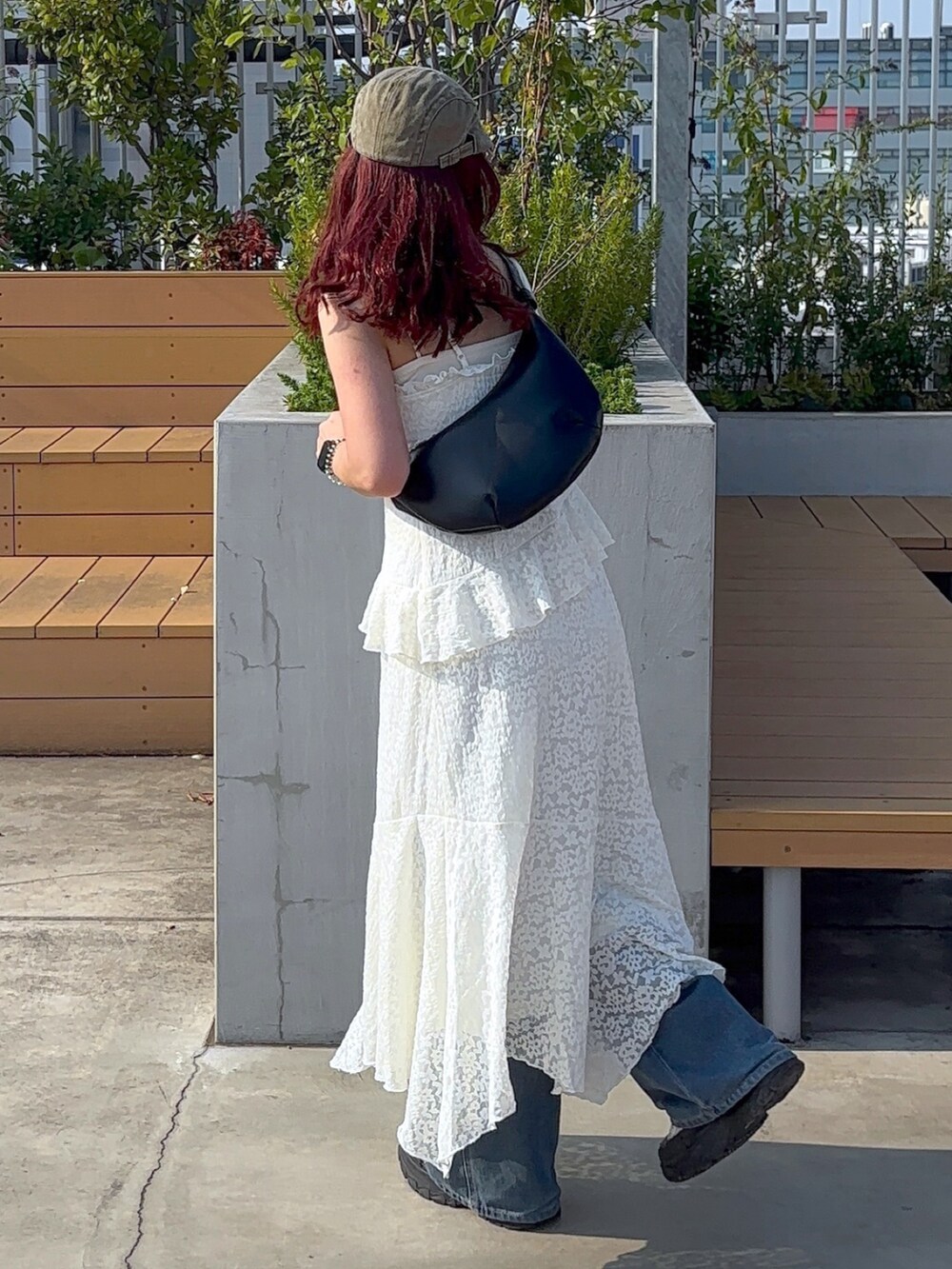 ホワイト系のワンピース、ブルー系のデニムパンツ、ホワイト系のスニーカーを着用したレディースの夏コーディネートの8枚目の写真