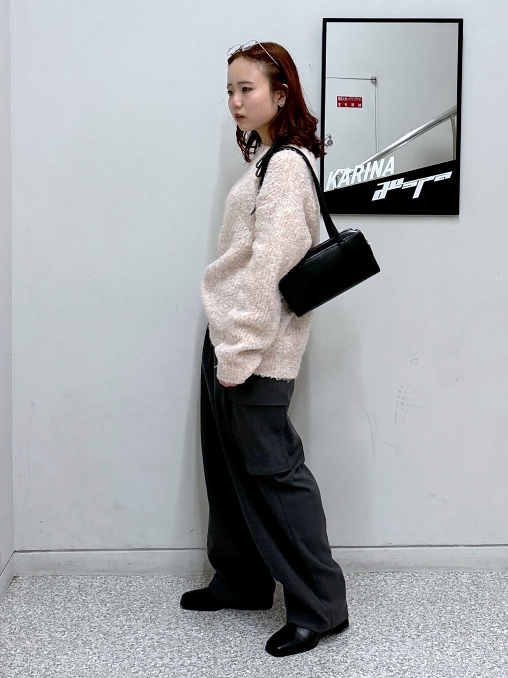 ピンク系のニット/セーター、グレー系のカーゴパンツ、ブラック系のブーツを着用したレディースの冬コーディネートの3枚目の写真