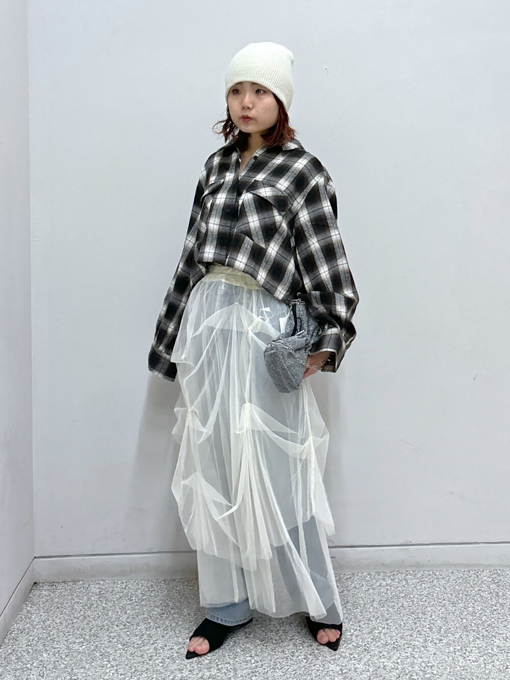 ブラウン系のシャツ/ブラウス、ホワイト系のスカート、ブルー系のデニムパンツを着用したレディースの秋コーディネートの2枚目の写真