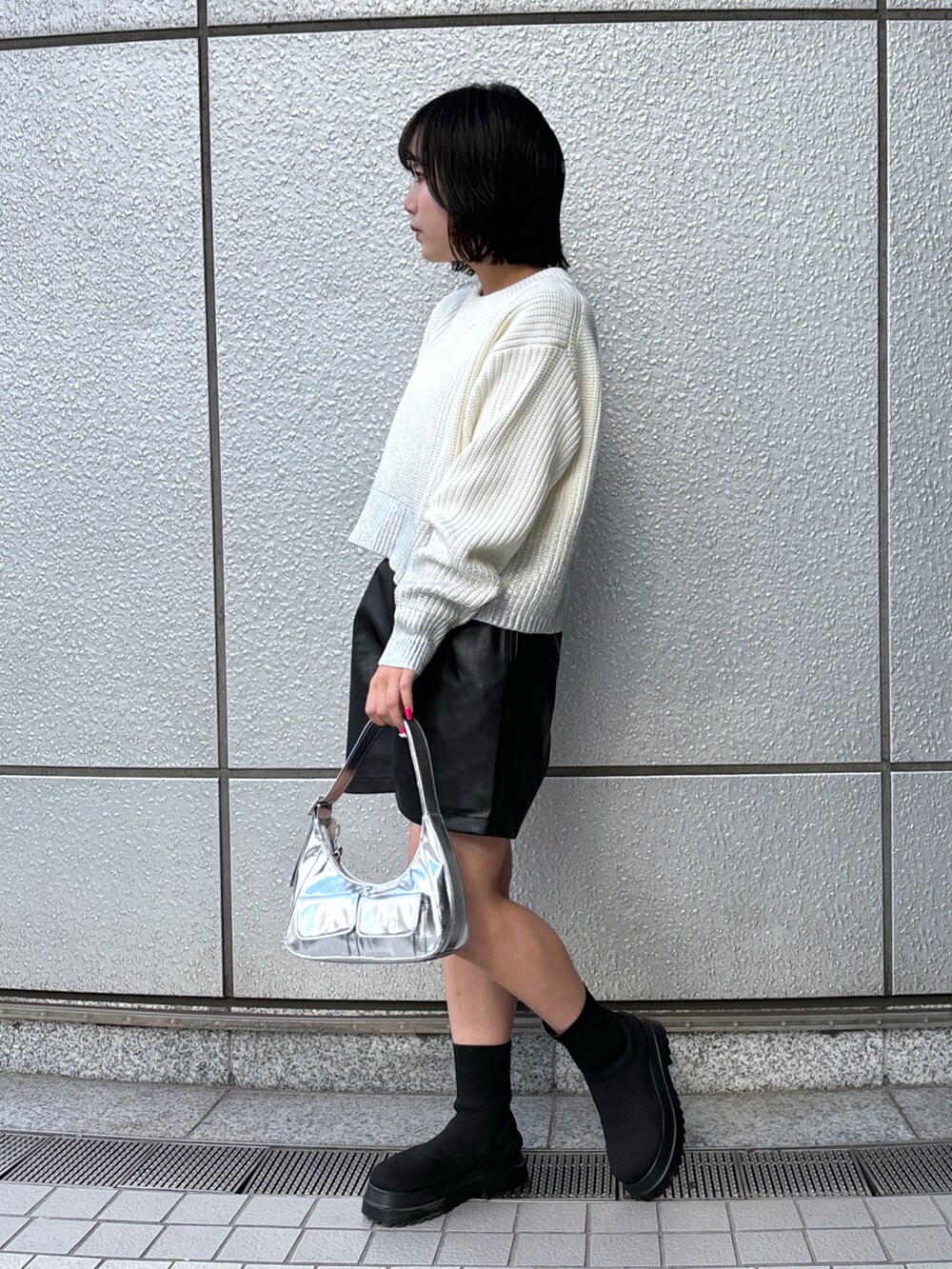 シルバー系のショルダーバッグ、ホワイト系のニット/セーター、ブラック系のその他パンツを着用したレディースの冬コーディネートの2枚目の写真