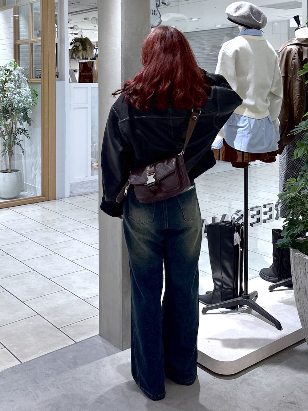 ブラック系のブルゾン、ブルー系のデニムパンツ、ブラウン系のショルダーバッグを着用したレディースの秋コーディネートの7枚目の写真