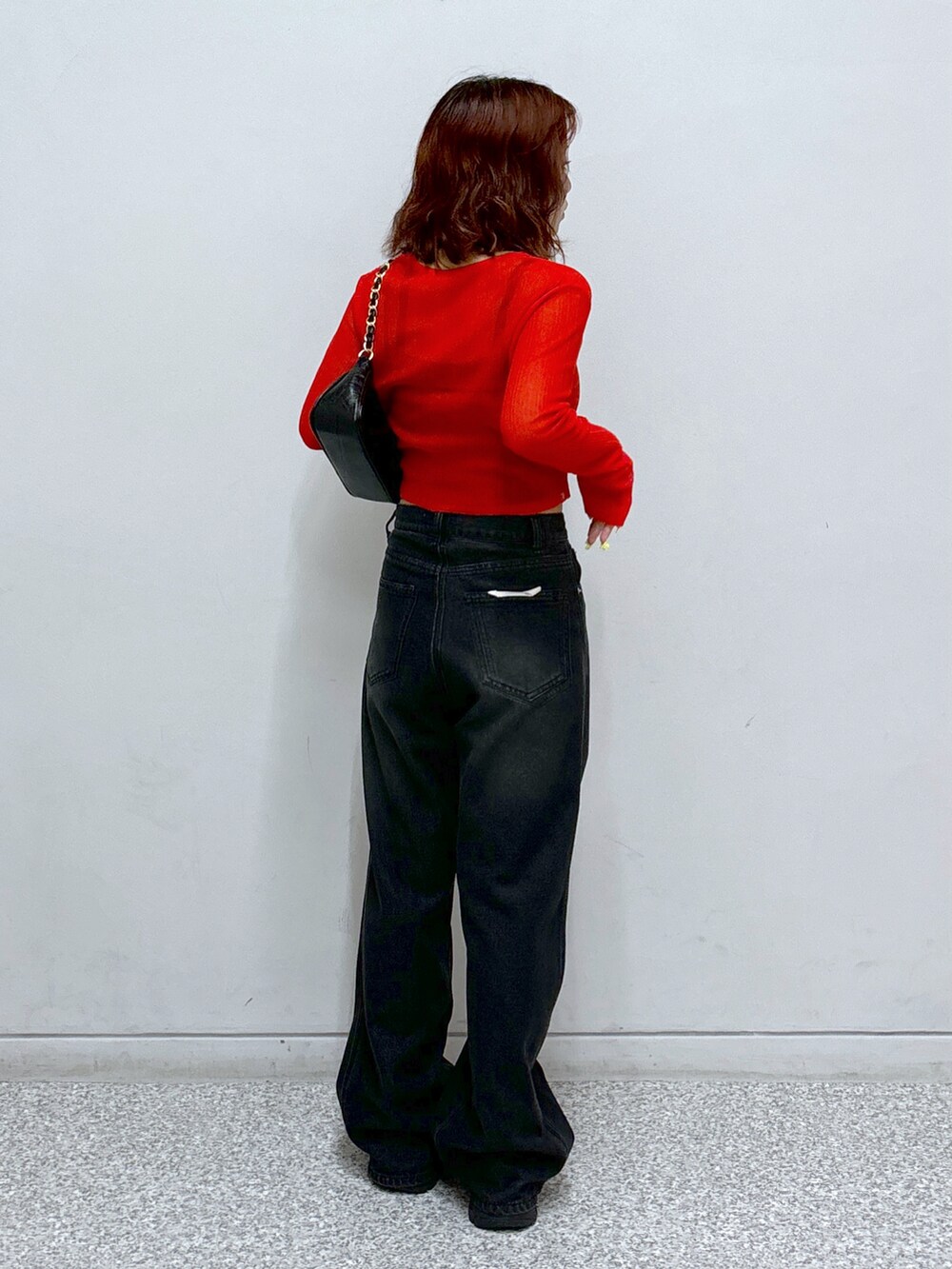 レッド系のカーディガン/ボレロ、ブラック系のトートバッグ、ブラック系のキャミソールを着用したレディースの秋コーディネートの5枚目の写真