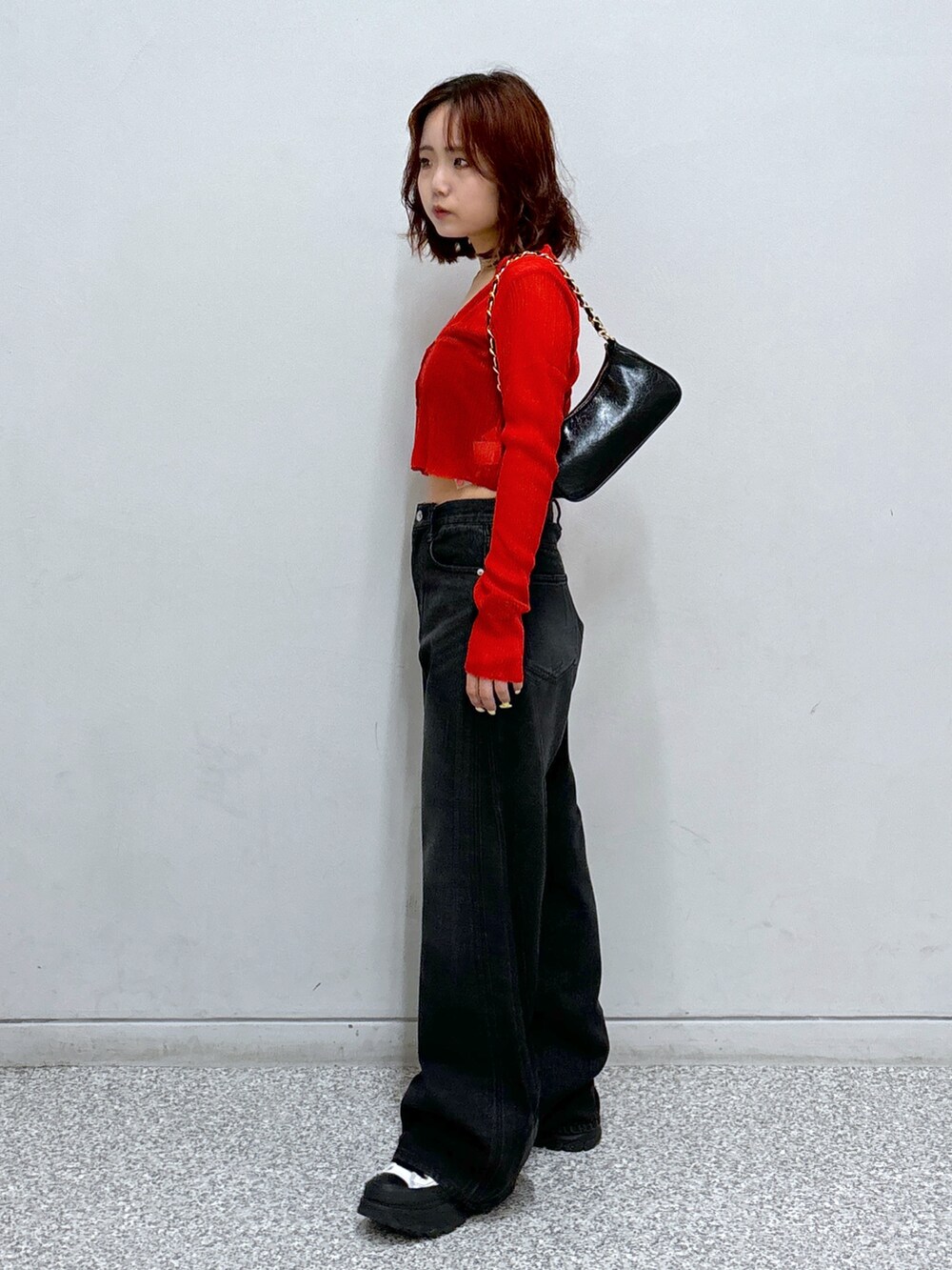 レッド系のカーディガン/ボレロ、ブラック系のトートバッグ、ブラック系のキャミソールを着用したレディースの秋コーディネートの3枚目の写真