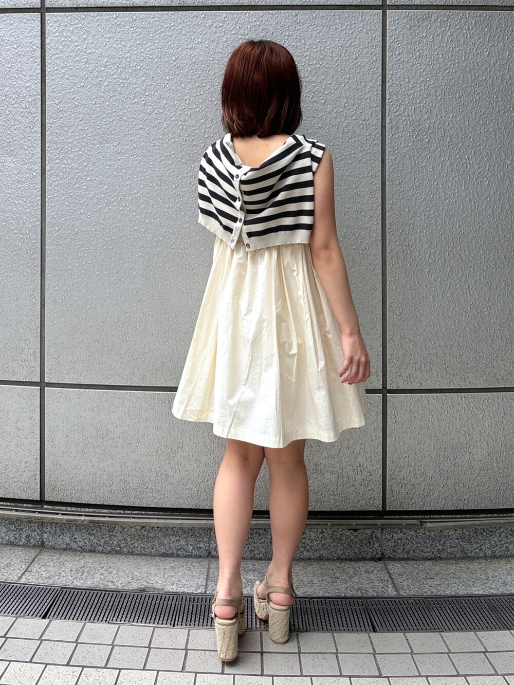 ホワイト系のワンピース、グレー系のカーディガン/ボレロ、グレー系のサンダルを着用したレディースの春コーディネートの5枚目の写真