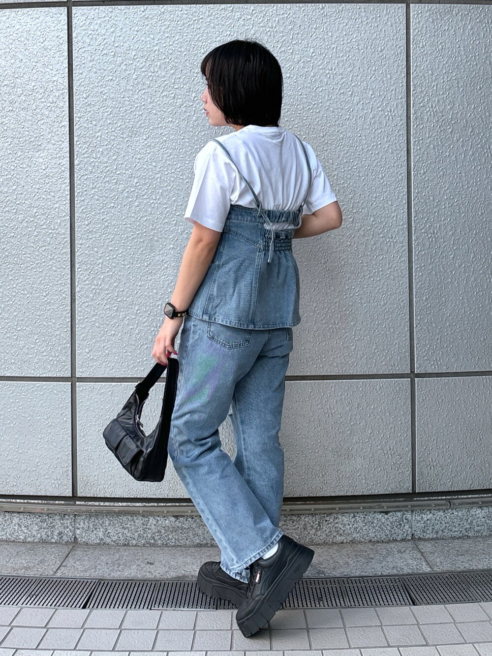 ブルー系のデニムパンツ、ブルー系のベスト、ホワイト系のTシャツ/カットソーを着用したレディースの春コーディネートの2枚目の写真