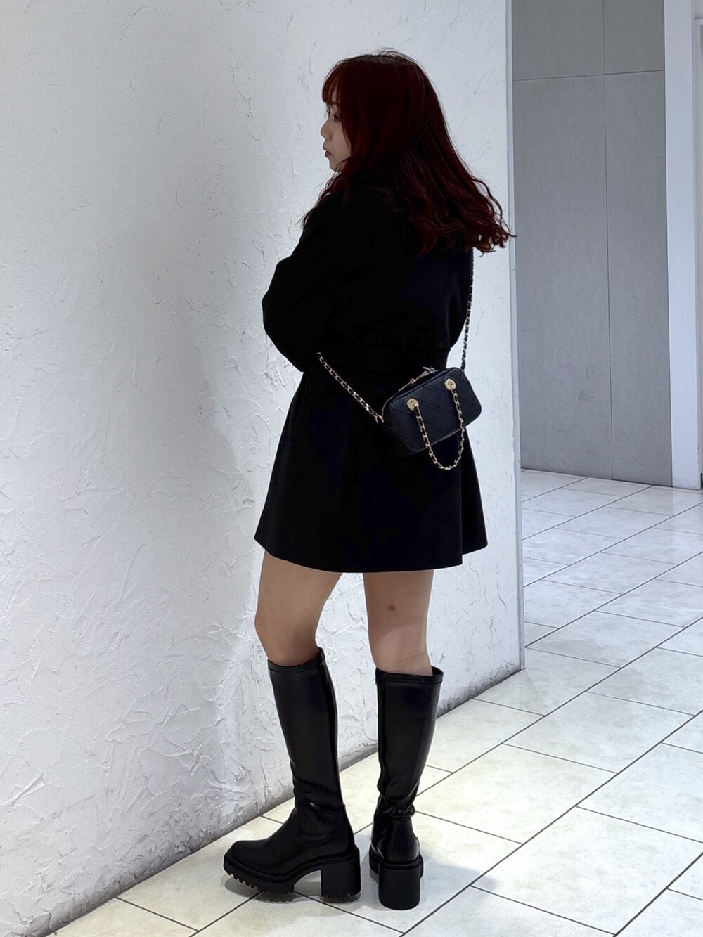 ブラック系のステンカラーコート、ブラック系のその他パンツ、ブラック系のショルダーバッグを着用したレディースの秋コーディネートの6枚目の写真