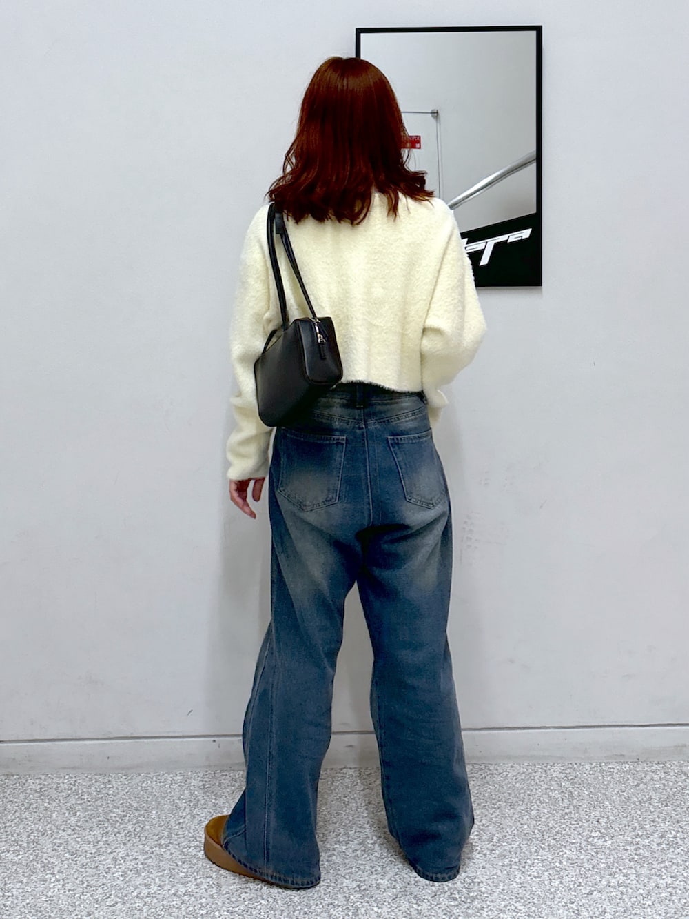 ホワイト系のカーディガン/ボレロ、ブラック系のショルダーバッグ、ブルー系のデニムパンツを着用したレディースの冬コーディネートの5枚目の写真