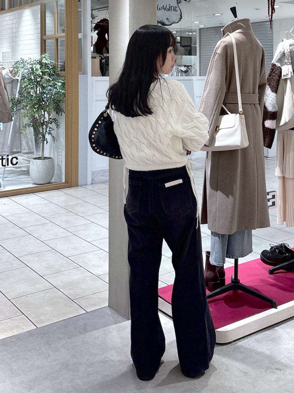 ホワイト系のニット/セーター、ブラック系のデニムパンツ、ブラック系のブーツを着用したレディースの冬コーディネートの10枚目の写真