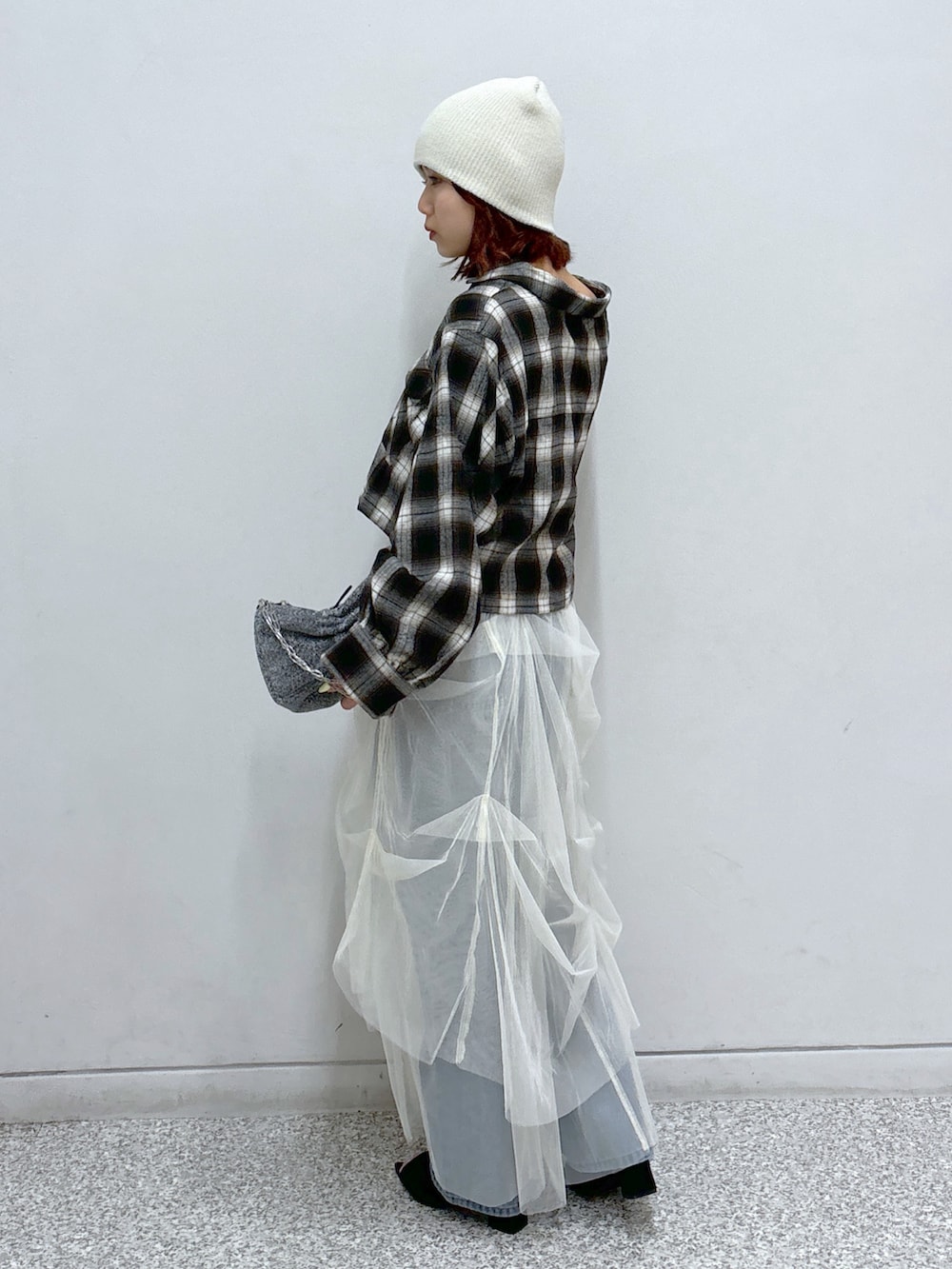 ブラウン系のシャツ/ブラウス、ホワイト系のスカート、ブルー系のデニムパンツを着用したレディースの秋コーディネートの3枚目の写真