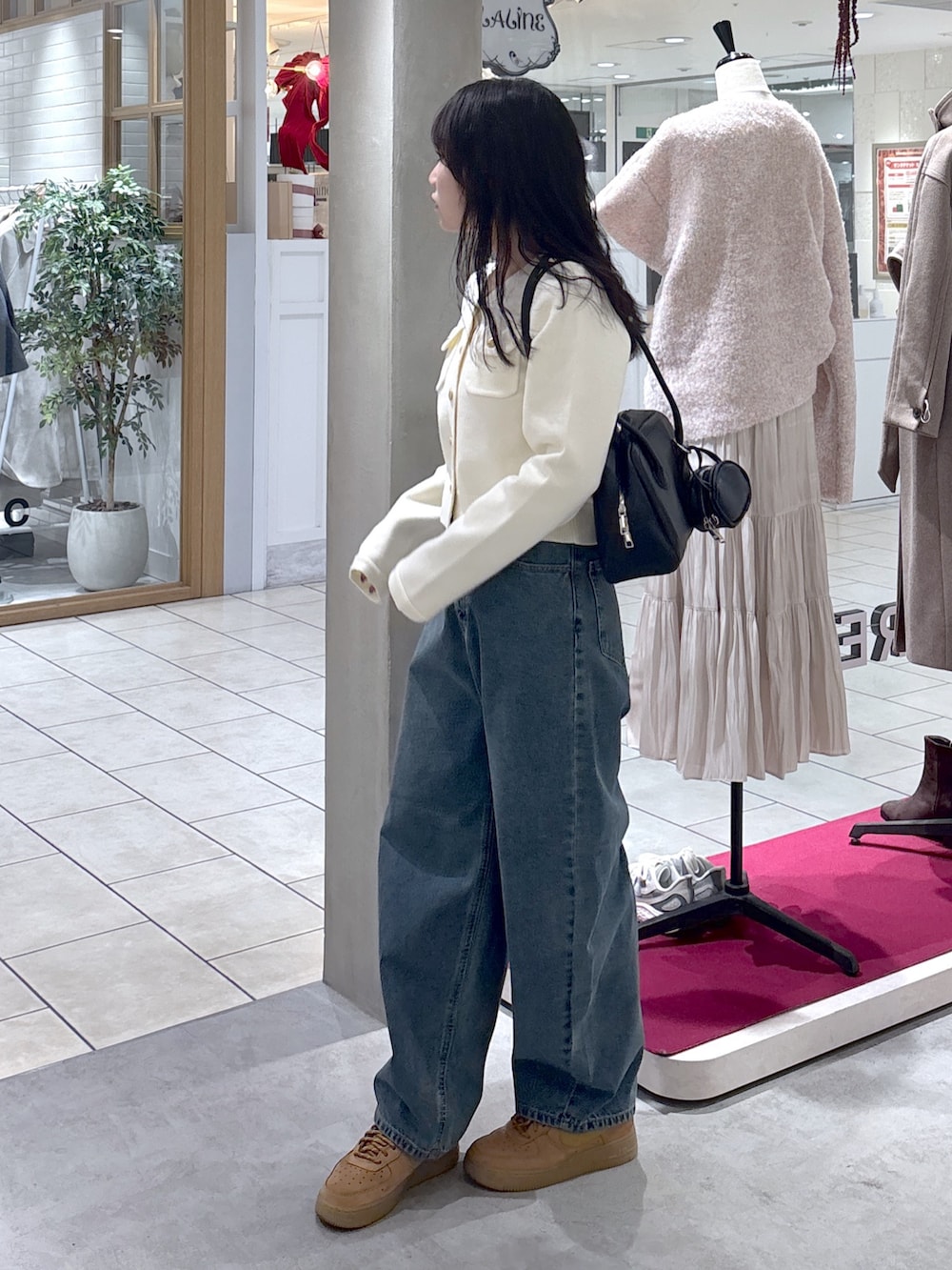 ホワイト系のニット/セーター、ベージュ系のスニーカー、ブラック系のハンドバッグを着用したレディースの冬コーディネートの5枚目の写真