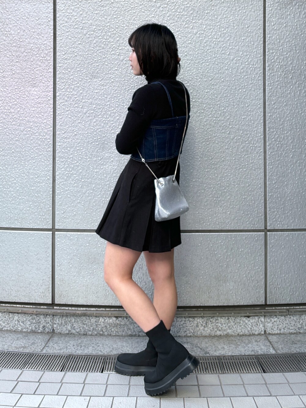 ブルー系のベスト、ブラック系のスカート、ブラック系のニット/セーターを着用したレディースの冬コーディネートの2枚目の写真