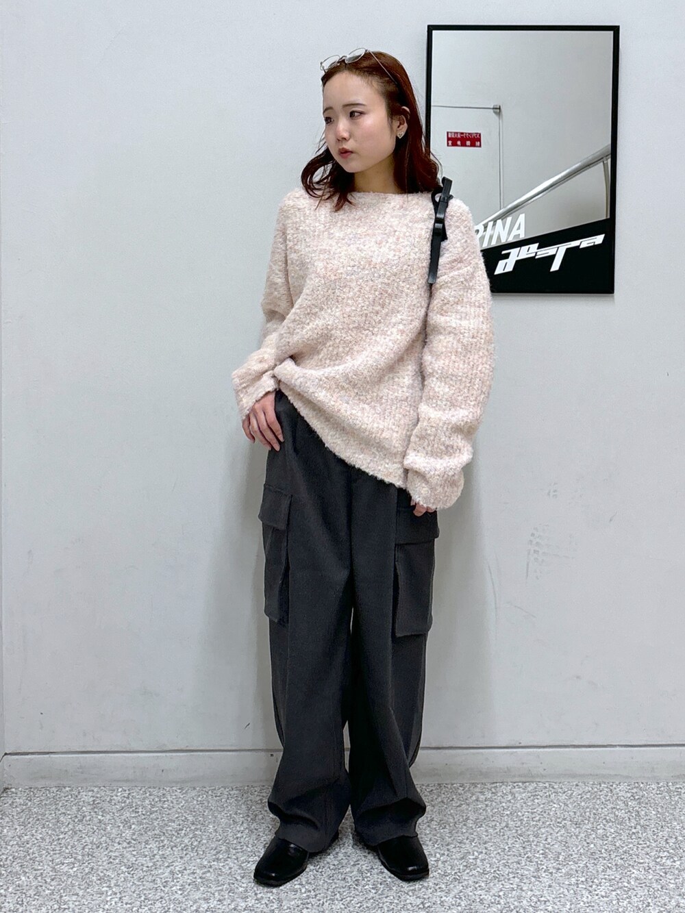 ピンク系のニット/セーター、グレー系のカーゴパンツ、ブラック系のブーツを着用したレディースの冬コーディネートの2枚目の写真