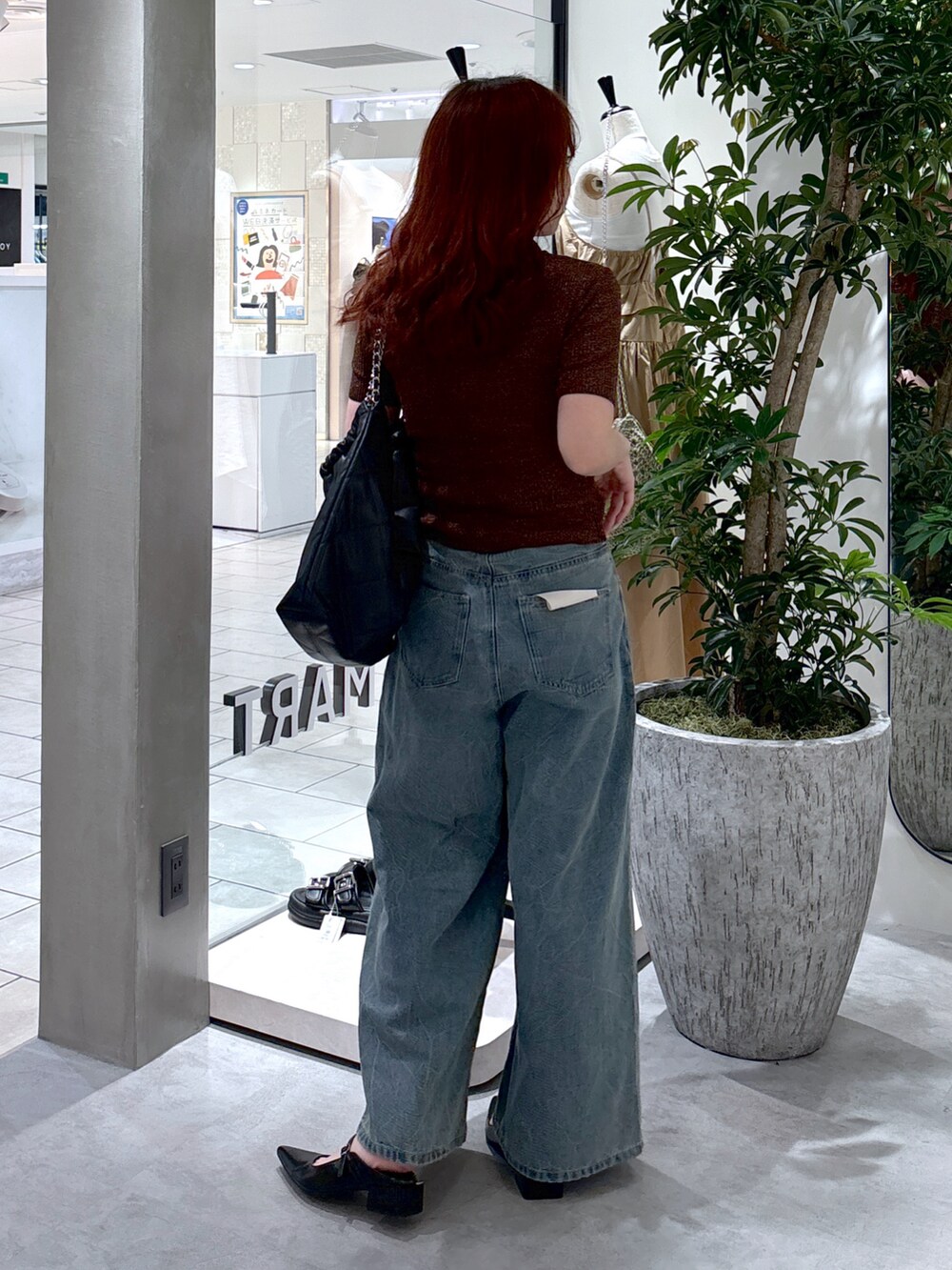 ブルー系のデニムパンツ、ブラック系のパンプス、ブラック系のトートバッグを着用したレディースの夏コーディネートの5枚目の写真