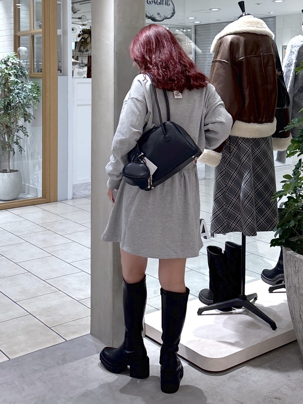 グレー系のワンピース、ブラック系のトートバッグ、ブラック系のブーツを着用したレディースの秋コーディネートの8枚目の写真